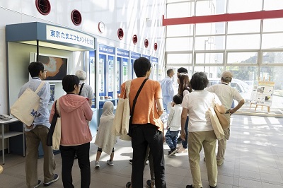 見学会の写真,焼却灰を原料として製造されるエコセメントについて説明が行われている様子