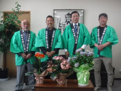 花鉢植えと市長と緑と花の祭典実行委員会役員の並んだ写真