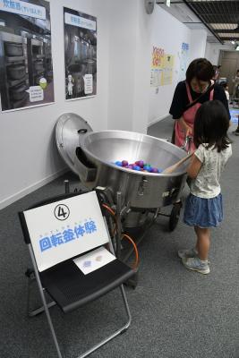 回転釜体験をする親子の写真