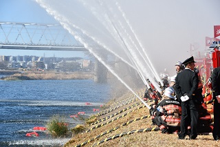 一斉放水をしている消防団員の写真