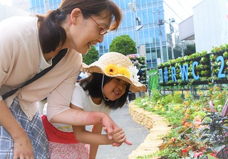 子供とお母さんが楽しそうに花を見ている写真