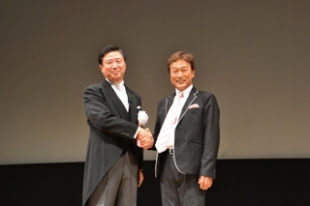 式典　長友市長と太川陽介さんと握手の様子